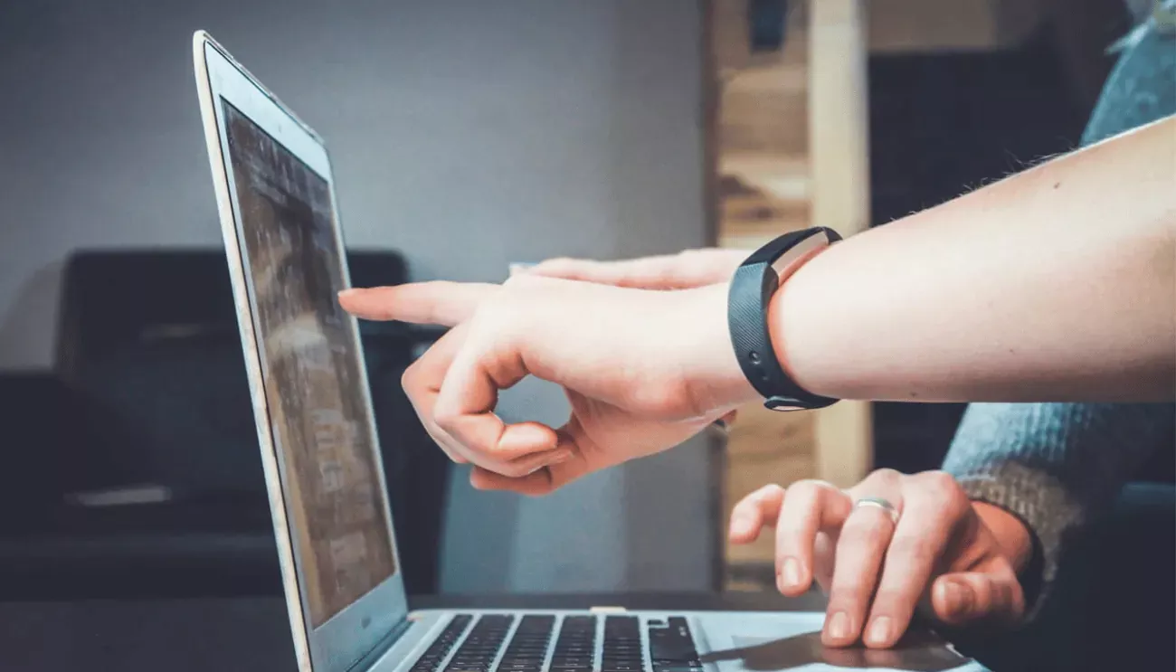 Person pointing at a laptop screen