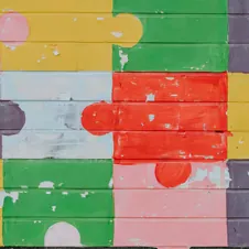 A painted wall with colorful interlocking puzzle pieces, symbolizing tailored solutions and problem-solving.