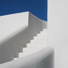 White stairs against a blue sky, symbolizing structured guidance and clear progression.