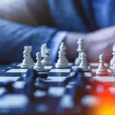 A chessboard with pieces in play, representing strategic thinking, planning, and a comprehensive approach to solutions.