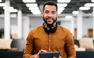 A professionally dressed man stands in a library setting