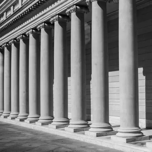 A row of grand stone columns, representing institutions, governance, and foundational stability.