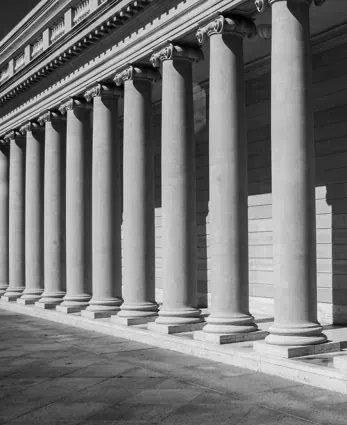A row of grand stone columns, representing institutions, governance, and foundational stability.