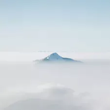 A mountain peak emerging from a sea of clouds, symbolizing clarity and focus.